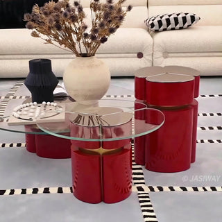 RINGCHEN modern cluster coffee table set featuring three modular nesting tables with premium tempered glass tops and sculptural petal-shaped metal bases in a bold red finish with gold accents. This luxury living room furniture set showcases a sophisticated clover-like silhouette and a sleek, high-gloss industrial design ideal for upscale interior decor.-Lifestyle front view