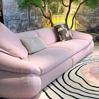 RINGCHEN modern curved cloud sofa featuring premium blush textured upholstery, highlighted by its signature sculptural low-profile silhouette, channel-tufted base detailing, and deep-seated organic cushioning for a high-end minimalist living room aesthetic.-Diagonal view