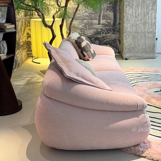RINGCHEN modern curved cloud sofa featuring premium blush textured upholstery, highlighted by its signature sculptural low-profile silhouette, channel-tufted base detailing, and deep-seated organic cushioning for a high-end minimalist living room aesthetic.-Side view