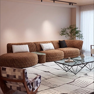 RINGCHEN modern Italian modular sectional sofa featuring a sculptural curved design and deep seat cushions, upholstered in a textured fabric. This low-profile luxury couch showcasing high-end craftsmanship, organic biomorphic contours, and an integrated small side table, designed for contemporary upscale living room decor and premium home styling.-Three quarter view