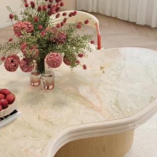 RINGCHEN sculptural cloud-shaped marble dining table featuring a luxury irregular cream-toned marble top with natural veining, supported by a sturdy dual solid wood pedestal base with a light natural oak finish, designed for modern minimalist and high-end designer dining rooms. -Close-up of tabletop texture