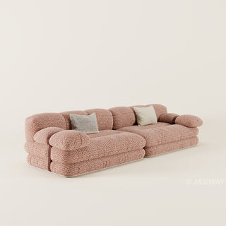 RINGCHEN luxury sculptural cluster jacquard sofa featuring a curved cloud-like silhouette, upholstered in premium textured designer fabric with a sophisticated pink and white micro-pattern, showcasing a low-profile modular frame, deep-seated comfort, and distinctive leather strap detailing on the rounded armrests for high-end living room interiors.-Three quarter view