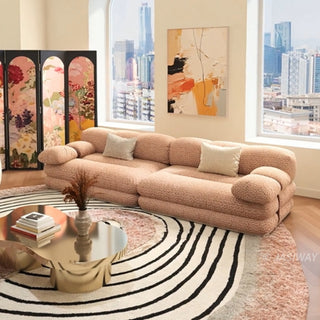 RINGCHEN luxury sculptural cluster jacquard sofa featuring a curved cloud-like silhouette, upholstered in premium textured designer fabric with a sophisticated pink and white micro-pattern, showcasing a low-profile modular frame, deep-seated comfort, and distinctive leather strap detailing on the rounded armrests for high-end living room interiors.-High-angle three quarter view