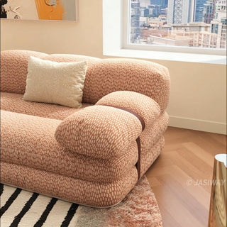 RINGCHEN luxury sculptural cluster jacquard sofa featuring a curved cloud-like silhouette, upholstered in premium textured designer fabric with a sophisticated pink and white micro-pattern, showcasing a low-profile modular frame, deep-seated comfort, and distinctive leather strap detailing on the rounded armrests for high-end living room interiors.-Close-up of armrest