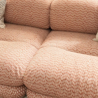 RINGCHEN luxury sculptural cluster jacquard sofa featuring a curved cloud-like silhouette, upholstered in premium textured designer fabric with a sophisticated pink and white micro-pattern, showcasing a low-profile modular frame, deep-seated comfort, and distinctive leather strap detailing on the rounded armrests for high-end living room interiors.-Close-up of material texture