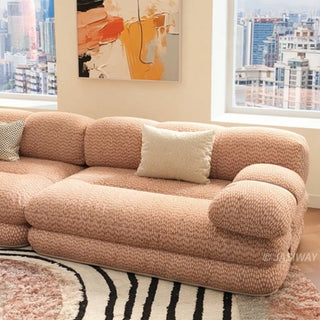 RINGCHEN luxury sculptural cluster jacquard sofa featuring a curved cloud-like silhouette, upholstered in premium textured designer fabric with a sophisticated pink and white micro-pattern, showcasing a low-profile modular frame, deep-seated comfort, and distinctive leather strap detailing on the rounded armrests for high-end living room interiors.-Medium shot