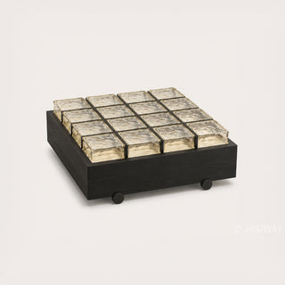 RINGCHEN sculptural coffee table with a grid of textured amber glass blocks set within a low-profile matte black wooden frame, highlighting the interplay of light through artisanal thick glass bricks, creating a sophisticated geometric cocktail table with a modern architectural silhouette and subtle spherical feet for a minimalist, grounded luxury aesthetic.-Three quarter view of single unit