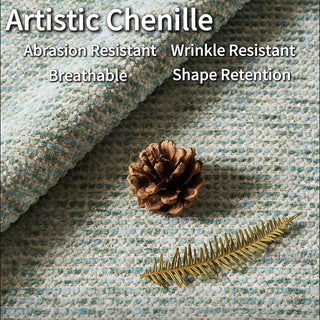 A close-up shot highlights the detailed texture of light blue and white artistic chenille fabric. A single brown pinecone and a golden fern leaf rest on top of the woven material. Text overlay highlights the fabric's key features, including abrasion resistance, wrinkle resistance, breathability, and shape retention.