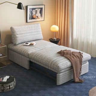 A warm beige striped sherpa convertible sleeper sofa is styled in a cozy living room with a brown throw blanket, open book, and warm ambient lighting.