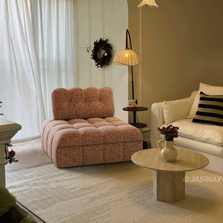 A rust red tufted chenille convertible sleeper sofa is styled in a cozy, warmly lit living room next to a white sofa, a round coffee table, and a floor lamp.