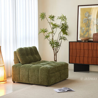 An olive green tufted chenille convertible sleeper sofa is styled in a bright, modern living room with a potted plant, a floor lamp, and an open magazine on the rug.