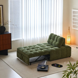 A green tufted chenille sleeper sofa bed is shown in a partially extended position within a bright living room, featuring a record player and vinyl records on the rug nearby.