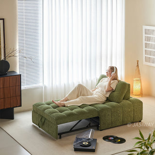 A young woman wearing headphones relaxes on an olive green tufted chenille convertible sleeper sofa bed in a sunlit modern living room with vinyl records nearby.