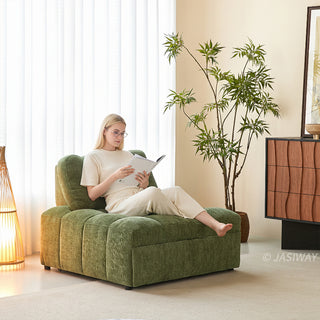 A young woman in glasses and a white outfit reads a book while relaxing on an olive green tufted chenille convertible sleeper sofa bed in a sunlit living room with a potted plant.