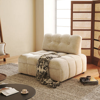 A beige tufted chenille convertible sleeper sofa is styled in a bright, modern living room with a patterned throw blanket and a wooden room divider.