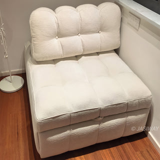 A beige tufted chenille convertible sleeper sofa is compactly arranged in an indoor corner setting with a wooden floor and white walls.